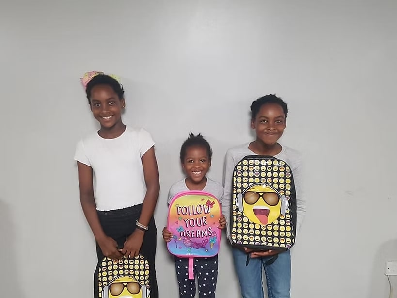 Children receiving school supplies from SMILE
